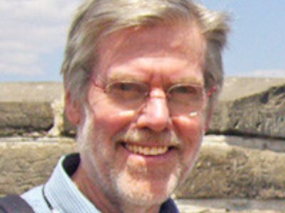 Hal Barwood is outdoors, wearing a shade in the picture.